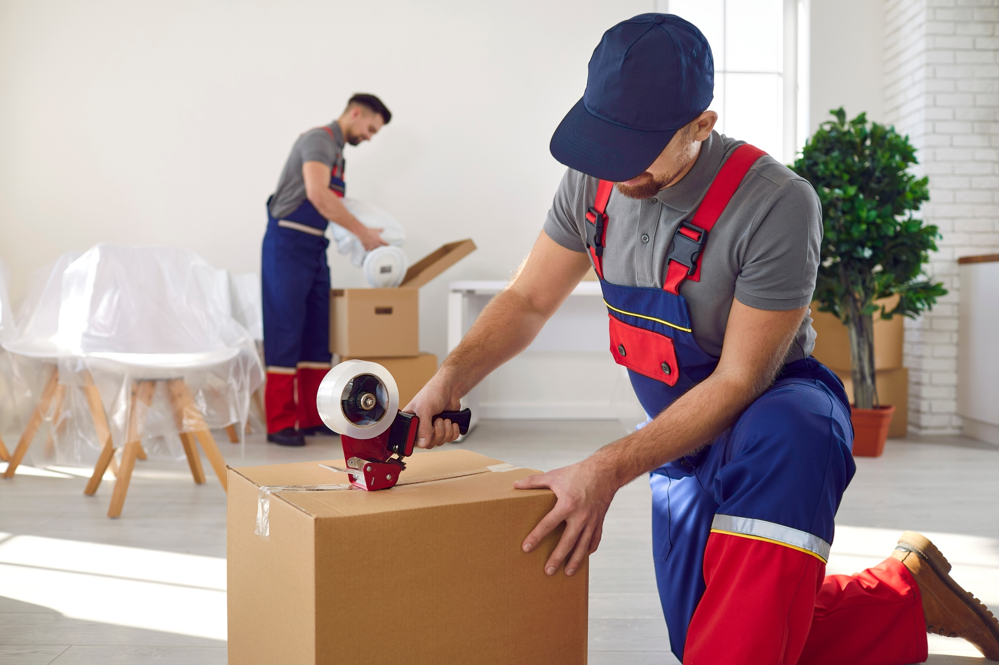 A Person in Overalls Packing a Box